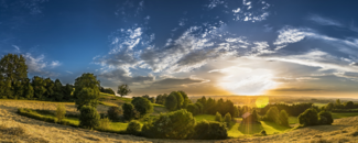 Photo of panoramic view of landscape with sun on horizon