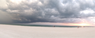 Photo of white beach at sunset with overcast sky