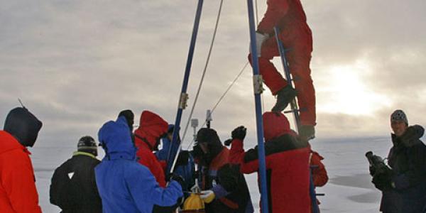 Photo of paleoclimatologists taking ice core samples in the Arctic