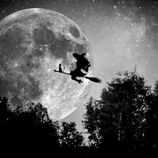 Silhouette of stereotypical Halloween witch and cat riding a broom against a full moon.