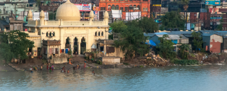 People wade into a river in front of a mosque that sits directly on the river bank in Kolkata, India.